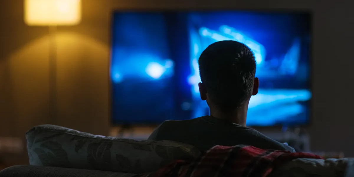 A man sitting on the couch watching television.